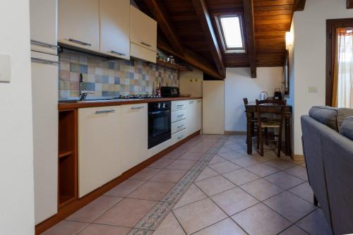 een keuken met witte kasten en een tafel. bij Dante's Skyview - Appartamento mansarda Novara STAZIONE in Novara