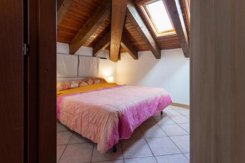 een slaapkamer met een bed in een kamer bij Dante's Skyview - Appartamento mansarda Novara STAZIONE in Novara