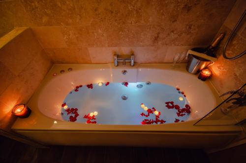 una bañera con velas y flores. en Howfield Manor Hotel en Canterbury