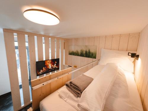 a bedroom with a bed and a tv on the wall at Horská Chata pod Soliskom in Vysoké Tatry