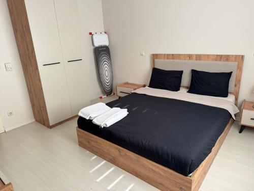 um quarto com uma cama com lençóis pretos e uma televisão em Ataşehir Residance 2+1 em Istambul