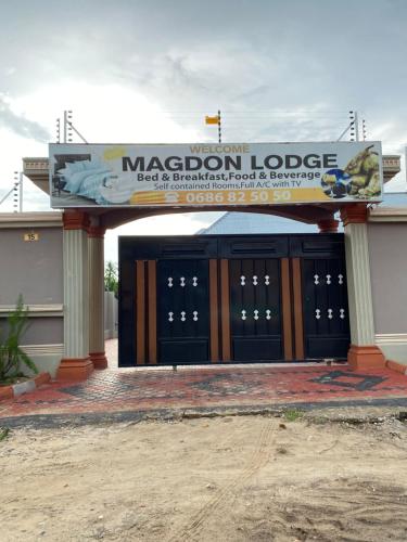 a large building with a sign for a macron lodge at Magdon Lodge in Dar es Salaam