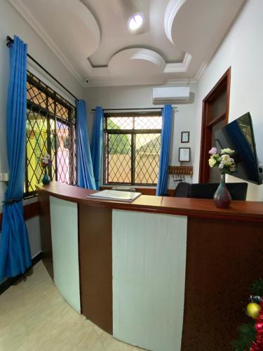 an office with a reception desk with blue curtains at Magdon Lodge in Dar es Salaam