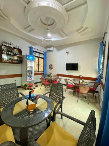 un soggiorno con tavolo e sedie di Magdon Lodge a Dar es Salaam