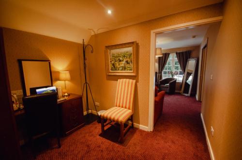 a hotel room with a chair and a mirror at Howfield Manor Hotel in Canterbury