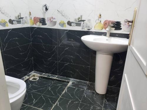 een zwart-witte badkamer met een wastafel en een toilet bij Guest House at the center of Addis Ababa. in Addis Ababa