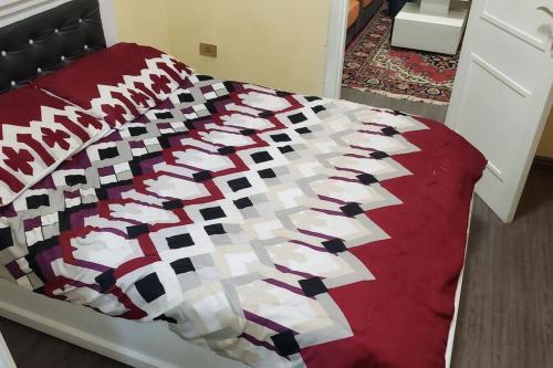 a bed with a red and white quilt on it at Guest House at the center of Addis Ababa. in Addis Ababa