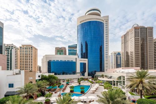 com vista para o horizonte da cidade e um edifício azul em Le Royal Meridien Abu Dhabi em Abu Dhabi