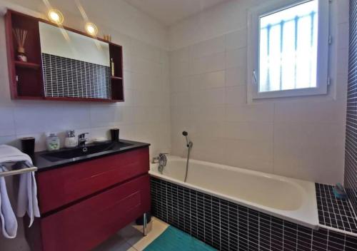La salle de bains est pourvue d'une baignoire et d'un lavabo. dans l'établissement Villa avec Piscine • Plage 15’, à Béziers