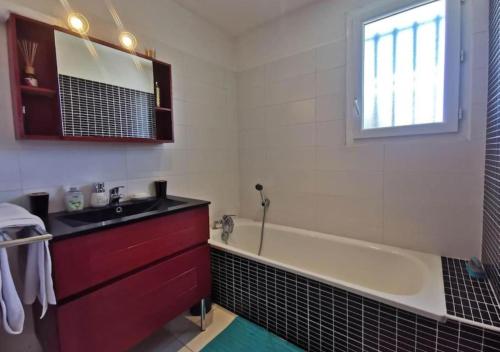une salle de bain avec une baignoire et un lavabo dans l'établissement Villa avec Piscine • Plage 15’, à Béziers