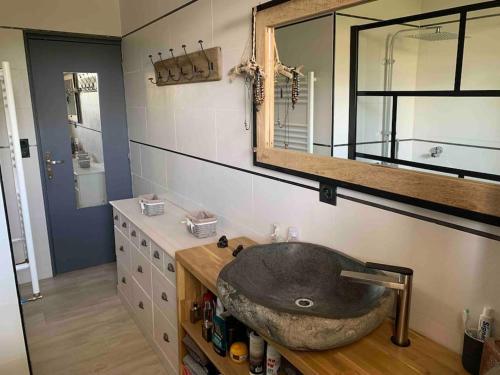 une salle de bain avec un lavabo en pierre et un miroir dans l'établissement Villa les n’amours piscine spa jacuzzi climatisé, à Béziers