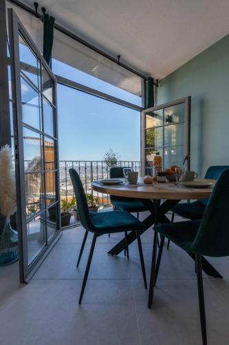 une salle à manger avec une table et des chaises et un balcon dans l'établissement Destination Grasse !, à Grasse