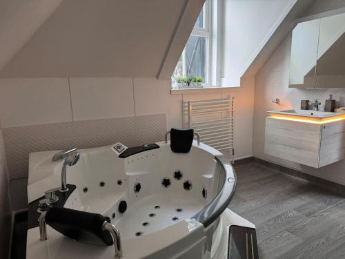 a bathroom with a bath tub and a sink at Beautiful Penthouse By Seafront in Brighton & Hove