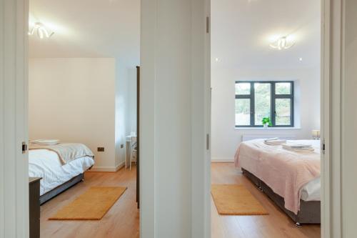 sypialnia z 2 łóżkami i oknem w obiekcie Cozy Two Bedrooms Flat in Coulsdon, CR5 w mieście Coulsdon