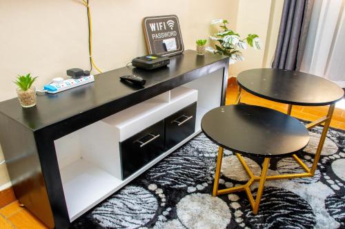 einen schwarzen Schreibtisch mit 2 Stühlen und einem Tisch in der Unterkunft AirBnB in Nairobi