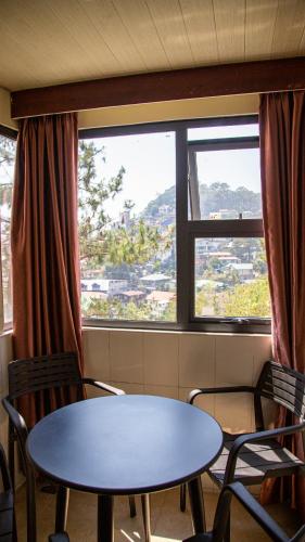 a table and chairs in a room with a window at 456 Hotel in Baguio