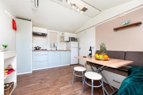 a kitchen and living room with a table and chairs at Glamping and Mobile Homes Lavanda - Holiday Centre Bi VIllage in Fažana