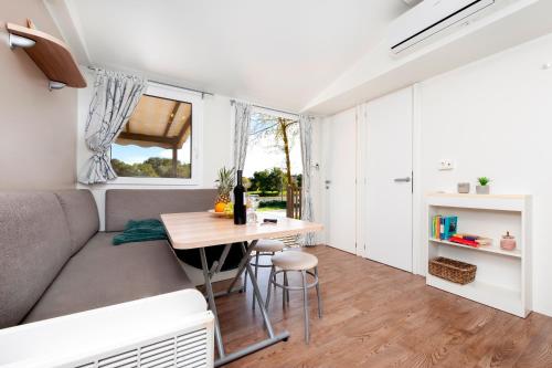 a living room with a couch and a table at Glamping and Mobile Homes Lavanda - Holiday Centre Bi VIllage in Fažana