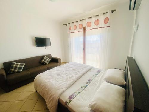 ein Schlafzimmer mit einem Bett und einem Sofa in der Unterkunft Cabo Dream Apparthotel in Cabo Negro