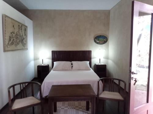 a bedroom with a bed with two chairs and two lamps at Casa Azul in Mindelo