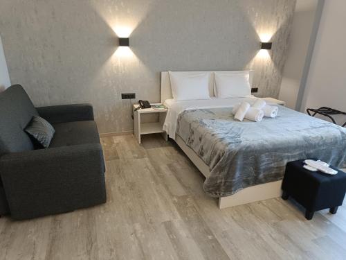 a hotel room with a bed and a couch at Oikos 9 Rooms and Suites in Nafpaktos