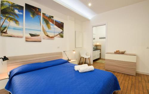 Schlafzimmer mit einem blauen Bett und einem Schreibtisch in der Unterkunft Awesome Apartment In Giardini Naxos With Wifi in Giardini-Naxos