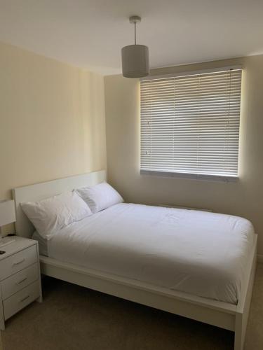 um quarto com uma cama branca e uma janela em 1 bed Flat Service Apartment Beckenham em Beckenham