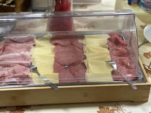 a display case with different types of meats and cheese at Hotel Morolli in Rimini