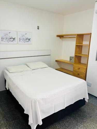 um quarto com uma grande cama branca num quarto em Via Venetto Flat em Fortaleza