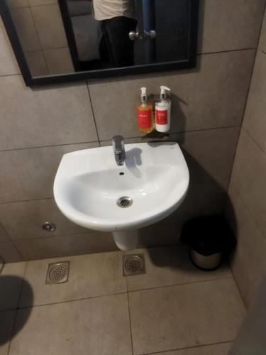 - białą umywalkę w łazience z lustrem w obiekcie Red Chilly B&B w mieście Gorakhpur