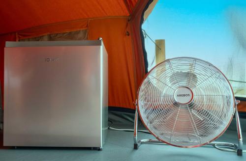 a metal fan sitting in front of a tent at Glamping Camp Faro in Faro