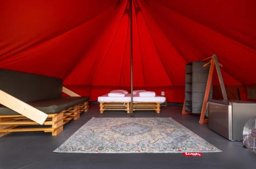 czerwony namiot z 2 łóżkami i dywanem w obiekcie Glamping Camp Faro w Faro