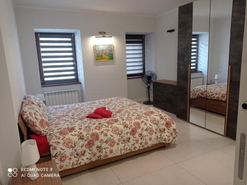een slaapkamer met een bed en een spiegel bij Sweet Home in Tolmezzo