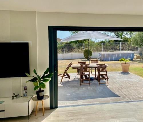 un patio avec une table, des chaises et un parasol dans l'établissement Villa de 100m² climatisée sur Mèze, à Mèze