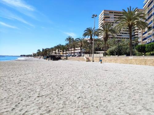 una playa de arena con palmeras y edificios en Seaside Retreat in Aguadulce with Ocean Views, en Aguadulce
