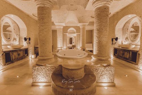 baño grande con columnas y bañera en el centro en Nino Cave Suites, en Ürgüp