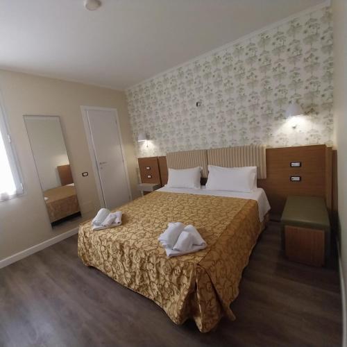 a hotel room with a bed with two towels on it at Hotel Montreal in Florence