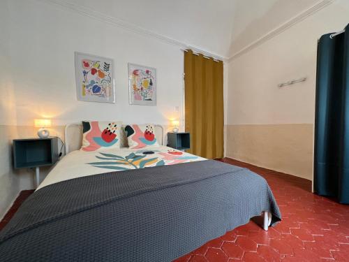 ein Schlafzimmer mit einem großen Bett mit einer blauen Decke in der Unterkunft Nature & Médiéval, gîte de charme 4 étoiles in Largentière