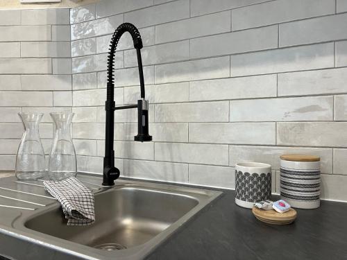 - un évier de cuisine avec un robinet d'eau noire dans l'établissement Nature & Médiéval, gîte de charme 4 étoiles, à Largentière