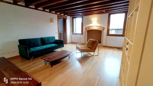 Lo Squero apt في البندقية: غرفة معيشة مع أريكة خضراء وكرسي