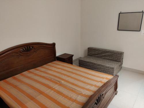 a bedroom with a bed and a chair at Zuhause apartment in Amritsar