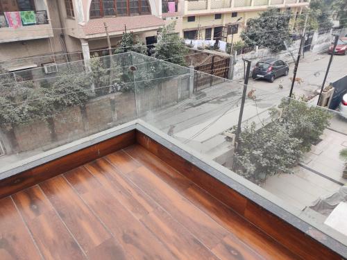 a balcony with a wooden floor and a view of a street at Zuhause apartment in Amritsar