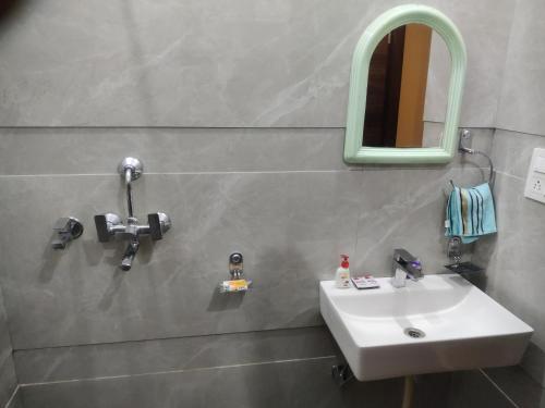 a bathroom with a sink and a mirror at Zuhause apartment in Amritsar