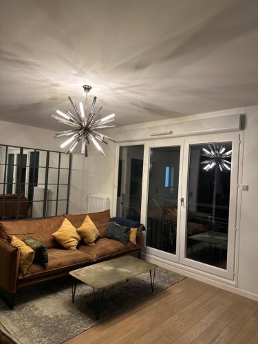 - un salon avec un canapé et un lustre dans l'établissement Très bel appartement de 4 pièces, à Saint-Ouen