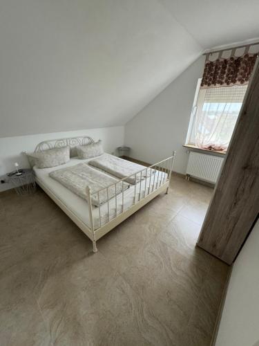 ein weißes Schlafzimmer mit einem Bett und einem Fenster in der Unterkunft SUNSHINE Apartments Rust-Ringsheim in Ringsheim