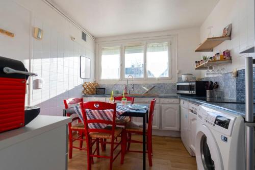 eine Küche mit einem Tisch und Stühlen sowie einer Waschmaschine in der Unterkunft La Maison Du Bonheur PARIS CDG AIRPORT, Bourget, Parcs Astérix,Expos, Disney Land, in Gonesse
