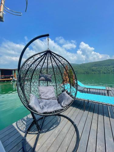 a swing chair on a dock next to a body of water at Splav ANDJELA Perucac in Perućac