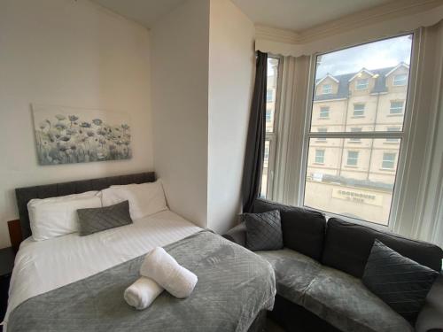 a bedroom with a bed and a couch and a window at Farina No4, Sea view apartment sleeping 4 guests in Bridlington
