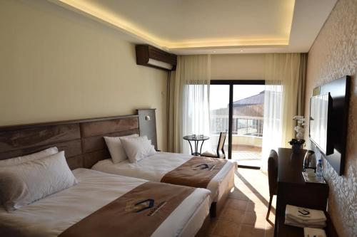 a hotel room with two beds and a balcony at Sands Hotel in Jbeil