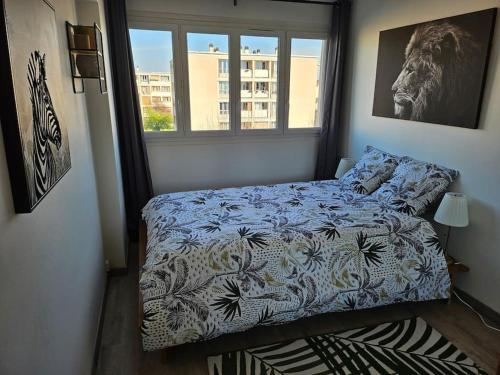 een slaapkamer met een bed en een raam bij Appartement Art deco proche bords de Marne in Neuilly-sur-Marne